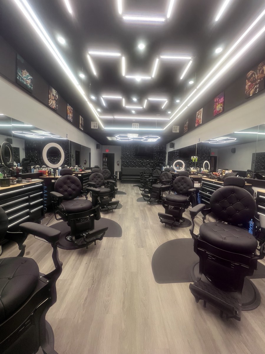 Interior of Fresh & Faded Barbershop with hexagon LED lighting and rows of black barber chairs