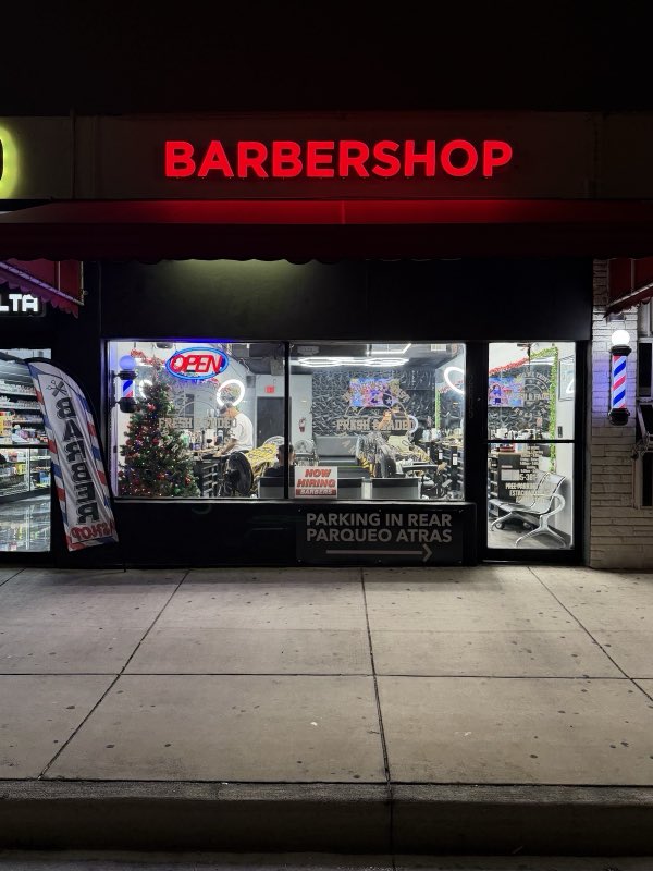 Fresh & Faded Barbershop storefront at night with red neon sign